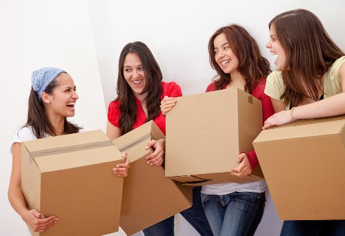 Local movers handling furniture in an East Ham street